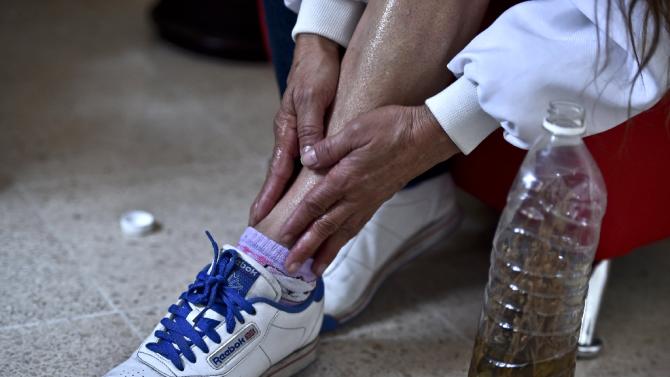 A woman applies a mixture of alcohol and marijuana to relieve muscle aches at a clandestine greenhouse in Mexico City