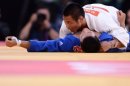 Japan's Masashi Ebinuma (white) competes with Korea's Cho Jun-Ho (blue) during the under-66kg quarter-final match