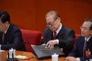 Chinese former president Jiang Zemin (C) puts his files into a bag during the closing of the 18th Communist Party Congress at the Great Hall of the People in Beijing on 14 November, 2012