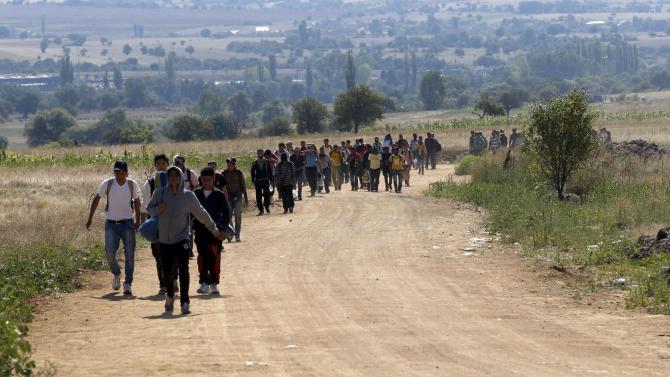 Migrants walk from the Macedonian border into Serbia, near the village of Miratovac, Serbia, Monday, Aug. 24, 2015. The more than 5,000 migrants who reached Serbia overnight faced an overcrowded refugee center where they have to apply for asylum — the paper that allows them three days to reach Hungary. (AP Photo/Darko Vojinovic)