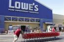 Lowe's workers collect shopping carts in the parking lot at the Lowe's Home Improvement Warehouse in Burbank
