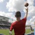 Football coach Jeff Fleener tosses a football to players during practice at the new $60 million football stadium at Allen High School Tuesday, Aug. 28, 2012 in Allen, Texas.  Allen High School northeast of Dallas christens the stadium Friday night with a matchup against defending state champion Southlake Carroll. While other school districts are struggling to retain teachers and keep classroom sizes down, Allen voters approved a $119 million bond issue that pays for the stadium and other district facilities. (AP Photo/LM Otero)