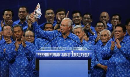 Malaysia's Prime Minister Najib Razak (C) holds his National Front coalition's manifesto during its launch ahead of the elections in Kuala Lumpur April 6, 2013. REUTERS/Bazuki Muhammad