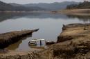 A car is revealed by the receding water in the Atibainha dam, part of the Cantareira System that provides water to the Sao Paulo metropolitan area, in Nazare Paulista, Brazil, Friday, Oct. 10, 2014. The dam is drying up due to the worst drought to hit Sao Paulo in 84 years. (AP Photo/Andre Penner)