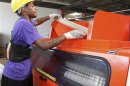 Worker Derrick Williams loads material into a cutting machine at a Wrap-Tite manufacturing facility in Solon, Ohio