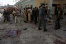 Afghan security forces inspect the site of a suicide attack in Jalalabad