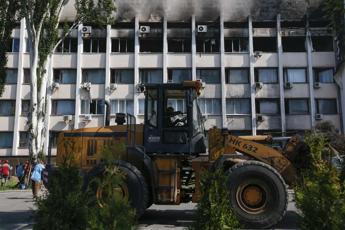 Workers of Metinvest, majority-owned by Rinat Akhmetov's System Capital Management, remove barricades and debris in front of the City Hall in Mariupol