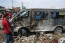 An Iraqi man looks at a destroyed mini bus at the site of car bomb attack in the northern city of Kirkuk, on June 4, 2014