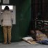 A man uses an ATM machine as a homeless man begs for alms from his makeshift bed in Madrid, Spain, Monday, April 22, 2013. The 2012 figures from Eurostat, the European Union's statistics office, showed Monday that in spite of efforts to get a handle on its debts, Spain saw its budget deficit rise to 10.6 percent of GDP in 2012 from 9.4 percent the year before as the country took US dlrs 52 billon (40 billion euro) in rescue loans to help its banks. Excluding the rescue funds, Spain says its deficit last year improved to just under 7 percent, above the initially pledged target of 6.3 percent. (AP Photo/Andres Kudacki)