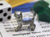 In this Tuesday, Feb. 5, 2013, photo, the newest Monopoly token, a cat, rests on a Boardwalk deed next to a die and houses at Hasbro Inc. headquarters, in Pawtucket, R.I. Hasbro Inc. reports quarterly financial results before the market opens on Monday, April 22, 2013.(AP Photo/Steven Senne)