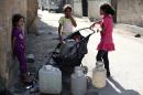 Syrian girls collect water for their families from a well in the town of Douma, near the capital Damascus, on July 28, 2014