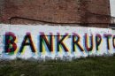 The word 'Bankruptcy' is seen painted on the side of a vacant building by street artists as a statement on the financial affairs of the city on Grand River Avenue in Detroit