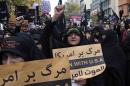 Iranian women chant slogans while holding anti-U.S. placards during a demonstration in front of the former U.S. Embassy, during Ashoura, when Muslim Shiites mark the death of 7th century Imam Hussein, in Tehran, Iran, Tuesday, Nov. 4, 2014. Thousands of Iranians chanted 