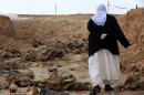 A member of the Yazidi minority searches for clues on February 3, 2015 that might lead her to missing relatives, among the remains of people killed by the Islamic State group