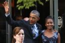 President Barack Obama waves as he walks out with his daughter Sasha in Washington