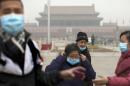 Tourists put on their masks after they posed for souvenir photos as they visit Tiananmen Square on a severely polluted day in Beijing, China, Tuesday, Feb. 25, 2014. Pollution across a large swath of northern China worsened on Tuesday. (AP Photo/Alexander F. Yuan)