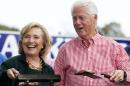 Former U.S. Secretary of State Hillary Clinton and her husband, former U.S. President Bill Clinton, hold up some steaks at the 37th Harkin Steak Fry in Indianola, Iowa.