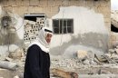 A man walks past a recently shelled area in Atareb