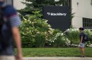 FILE- In this Tuesday, July 9, 2013, file photo, pedestrians walk near BlackBerry's headquarters in Waterloo, Ontario, on the morning of the company's Annual General Meeting. BlackBerry said Friday, Sept. 20, 2013, it will lay off 4,500 employees, or 40 percent of its global workforce, and is announcing a nearly $1 billion second-quarter loss in a surprise early release of earnings. (AP Photo/The Canadian Press, Geoff Robins, File)