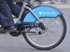 The Barclays logo is seen on rental bike ridden by commuter in London