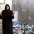 In this photo from Sunday, Aug. 5, 2012, Fatoum Obeid, 50, stands in a pile of trash left by Syrian soldiers who occupied her home in Atarib, Syria. In recent months rebels have seized a huge swath of territory in northern Syria, giving them a freedom to move and organize unprecedented in the 17-month conflict. (AP Photo/Ben Hubbard)