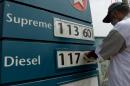 A Pakistani petrol station worker changes the price at a filling station in Karachi on October 1, 2013