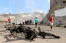 Yemenis inspect the scene of a car bomb attack that killed a Yemeni senior official in the southern port city of Aden, Yemen, Sunday, Dec. 6, 2015. A huge explosion killed the governor of Yemen's southern Aden province and six of his bodyguards on Sunday, security officials said, in an attack that was later claimed by a local Islamic State affiliate. (AP Photo/Wael Qubady)