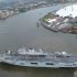 In this photo issued by Britain's Ministry of Defence, showing 150 sailors and aircrew recreating the Olympic Rings on the flight deck of HMS Ocean, to mark the start of the ship's Olympic deployment as it arrives Friday July 13, 2012 at Greenwich on the River Thames in London, where she will be acting as a helicopter landing platform and logistics hub.  The 21,500 ton helicopter carrier will also be home for 400 military personnel providing security in Greenwich Park, where the equestrian events and modern pentathlon will take place. The O2 arena, dome at top right, which is being renamed as the North Greenwich Arena during the Olympic Games. (AP Photo/MoD) NO SALES