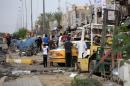 Iraqis inspect the site of a suicide car bomb attack in the Baghdad neighbourhood of Talbiya on October 16, 2014