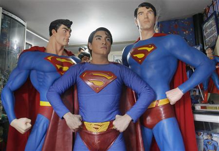 Herbert Chavez poses with his life-sized Superman statues inside his house in Calamba Laguna, south of Manila