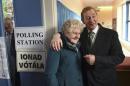 Irish Prime Minister Enda Kenny stands with 88-year-old Bridie McLoughlin in a polling station at St Anthony's School in Castlebar