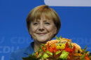 German Chancellor Angela Merkel, chairwoman of the Christian Democratic party CDU, holds flowers at the party headquarters in Berlin Sunday, Sept. 22, 2013. ARD and ZDF television projections Sunday showed a wide lead for Merkel's conservative Union bloc over challenger Peer Steinbrueck's Social Democrats. (AP Photo/Matthias Schrader)