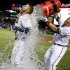 Atlanta Braves' Freddie Freeman, left, is doused with water by Eric Hinske after Freeman hit a home run in the ninth inning as the Braves beat the Marlins 4-3 to clinch at least an NL wild-card playoff berth Tuesday, Sept. 25, 2012, in Atlanta. (AP Photo/David Goldman)