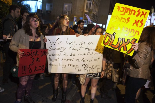 Israeli women hold placards as they take part in a 'slut walk' protest in Tel Aviv