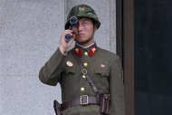A North Korean soldier looks south through a pair of binoculars on the north side of the truce village of Panmunjom in the demilitarised zone separating the two Koreas in Paju, about 55 km (34 miles) north of Seoul, August 25, 2010. REUTERS/Jo Yong-Hak