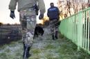 Gendarmes walk along the Dordogne river, on December 21, 2013 in Lugon-et-l'Ile-du-Carnay, France, after a helicopter carrying a Chinese tea tycoon overflying his newly-purchased vineyard went down