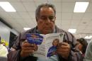 Dominguez, who does not have health insurance, reads a pamphlet at a health insurance enrollment event in Cudahy, California