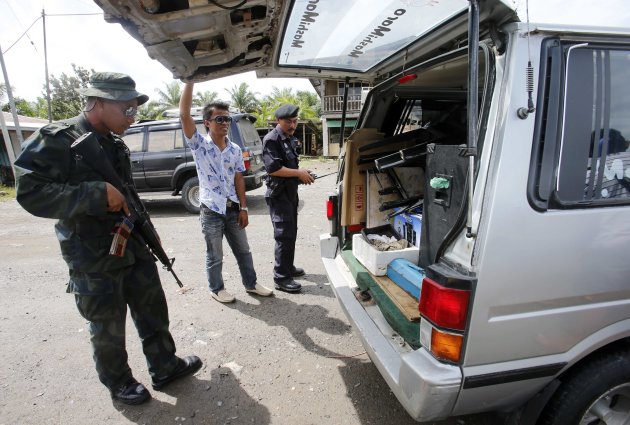 Malaysia's armed police inspect a vehicle outside Lahad Datu in the state of Sabah on Borneo island