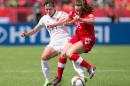 China's Wang Lisi (L) vies with Canada's Allysha Chapman during their Group A football match at Commonwealth Stadium during the opening match of the FIFA Women World Cup in Edmonton, Canada, on June 6, 2015