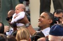 President Barack Obama holds up a baby at a campaign event at Elm Street Middle School, Saturday, Oct. 27, 2012 in Nashua, N.H. (AP Photo/Jim Cole)