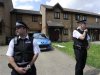 Police officers stand outside a house in Stratford east London