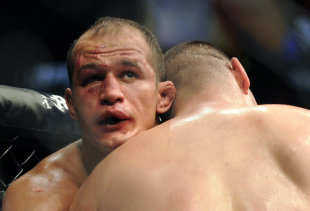 Junior dos Santos grapples with Cain Velasquez during their grueling fight. (AP)