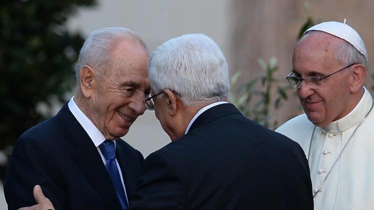 Israeli President Shimon Peres (left) shakes hands with Palestinian leader Mahmud Abbas as Pope Francis looks on following a peace summit at the Vatican, on June 8, 2014