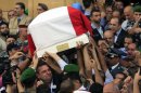 A Lebanese honor guard carries a coffin wrapped with Lebanese flags of Brig. Gen. Wissam al-Hassan, who was assassinated on Friday by a car bomb, during their funeral procession at Martyrs' Square in Beirut, Lebanon, Sunday, Oct. 21, 2012. Thousands of Lebanese waving the national flag packed a central square in downtown Beirut Sunday for the funeral of a top intelligence official assassinated in a car bombing that many blame on the regime in neighboring Syria. (AP Photo/Bilal Hussein)