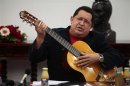 Venezuelan President Chavez plays a guitar, which was a gift from Mexican singer Vicente Fernandez, during a cabinet meeting at Miraflores Palace in Caracas