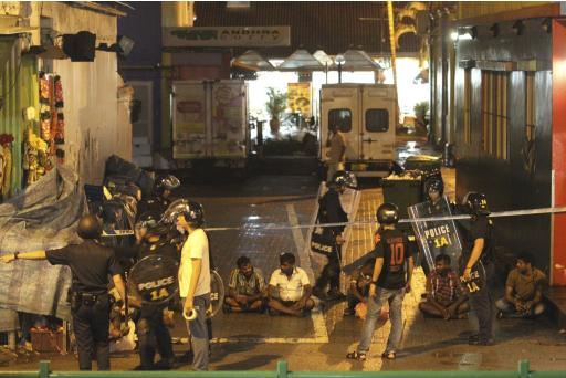 Police detain men following a riot in Singapore's Little India district