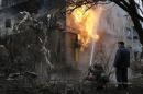 A firefighter works to extinguish a fire at a residential block, which was damaged by a recent shelling, on the outskirts of Donetsk, eastern Ukraine