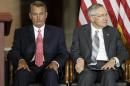 In this Sept. 10, 2014, photo, House Speaker John Boehner of Ohio, left, sits with Senate Majority Leader Harry Reid of Nev., on Capitol Hill in Washington, as Congress honored victims of the terror attacks of September 11, 2001, during a "Fallen Heroes of 9/11 Gold Medal Ceremony." The House and Senate are controlled by different political parties, but both are spending time these days on similar paths: debating measures that everyone knows are going nowhere. (AP Photo/J. Scott Applewhite)