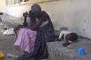 A South Sudanese woman with a child sits on December 25, 2013 at the main hospital in Bor