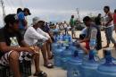 People wait in line to buy bottles of water in San Jose del Cabo